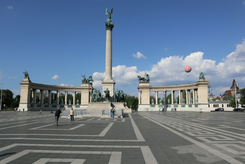 A group of people standing in a parking lot next to a monument