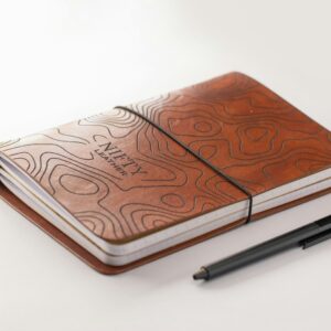 a notebook with a pen on top of it