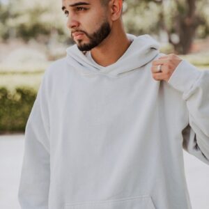 a man with a beard wearing a white hoodie